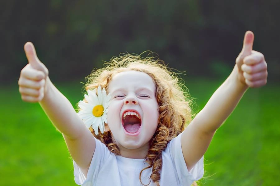 一個小女生，開心大笑的雙手比讚