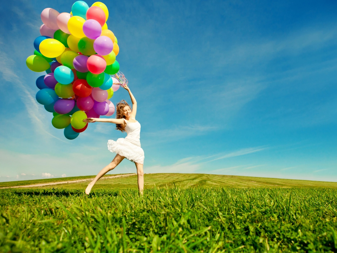 一個女生抓一束氣球快樂的跳耀